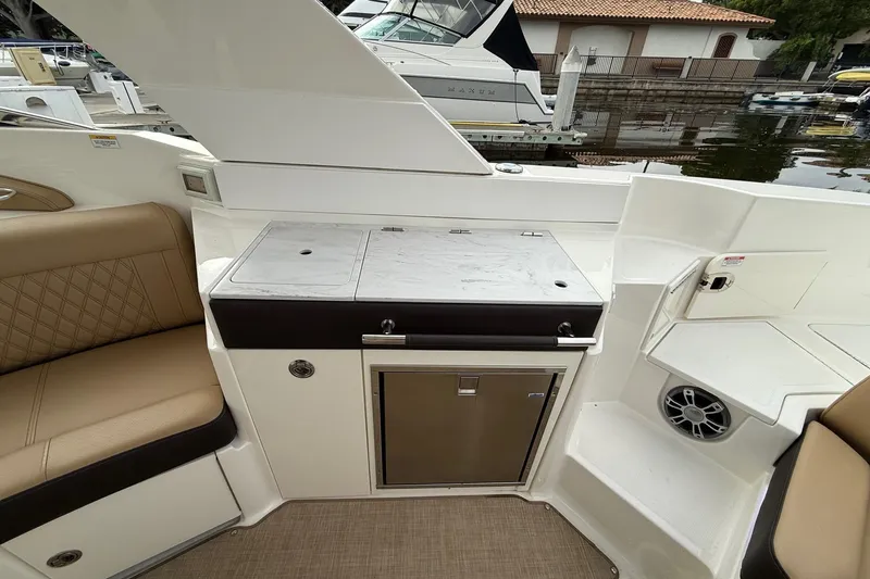Slide: The Image of 2023 Sea Ray SLX 350 boat interior with tan seating and built-in speakers. - 14