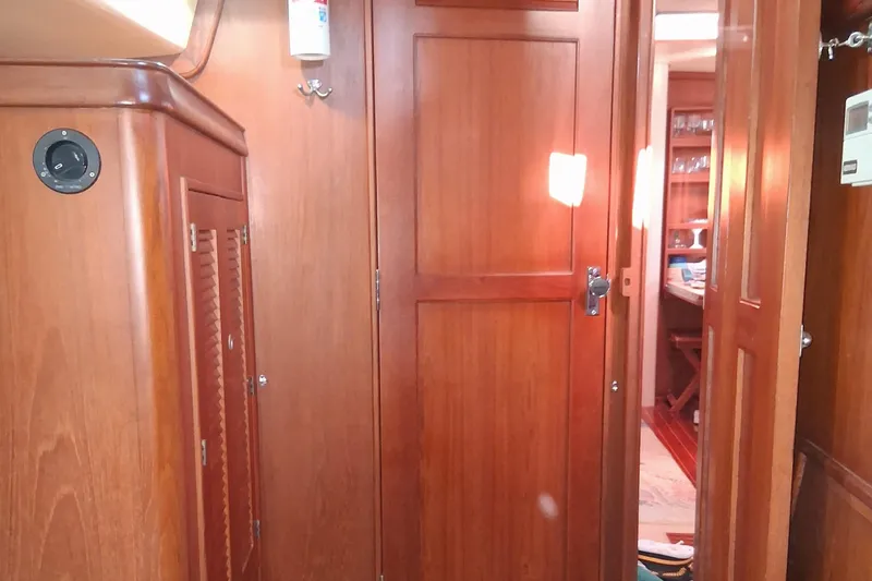 Slide: The Image of Interior of 1994 Island Packet 44 cutter, featuring wooden cabinetry and doors. - 100