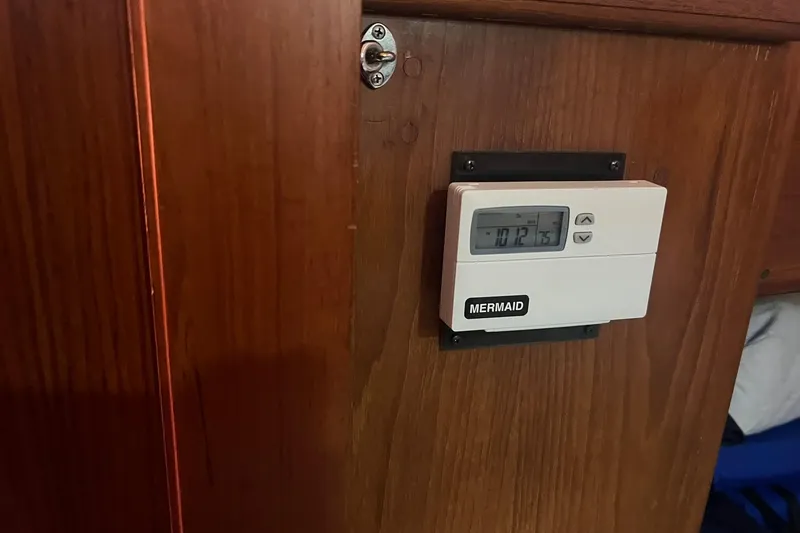 Slide: The Image of Thermostat on wooden panel inside 1994 Island Packet 44 cutter sailboat. - 101