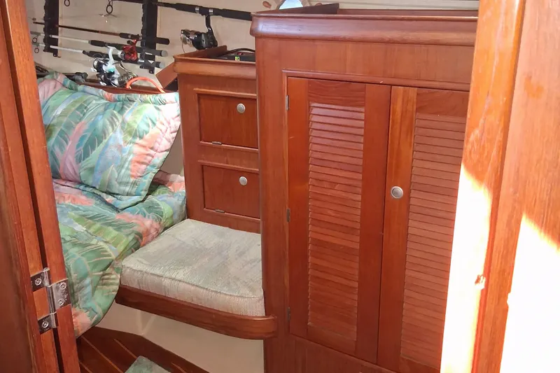 Slide: The Image of Cozy cabin interior of 1994 Island Packet 44 cutter with wooden cabinetry and fishing rods. - 102