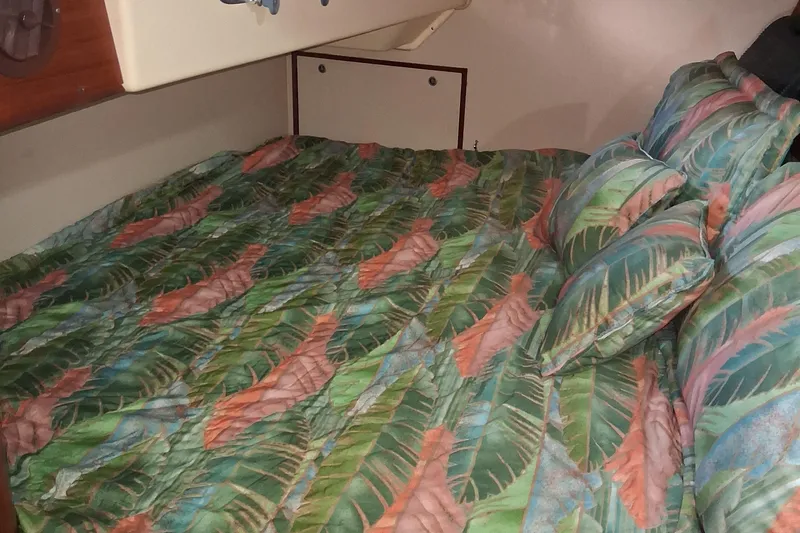 Slide: The Image of Cozy cabin bed with tropical leaf-patterned bedding on a 1994 Island Packet 44 cutter. - 103