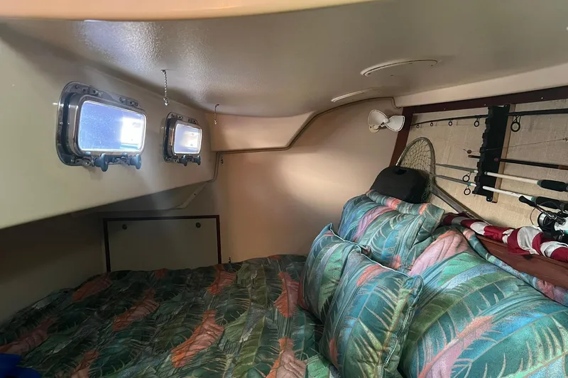 Slide: The Image of Cozy cabin interior of 1994 Island Packet 44 cutter with tropical bedding and fishing gear. - 104