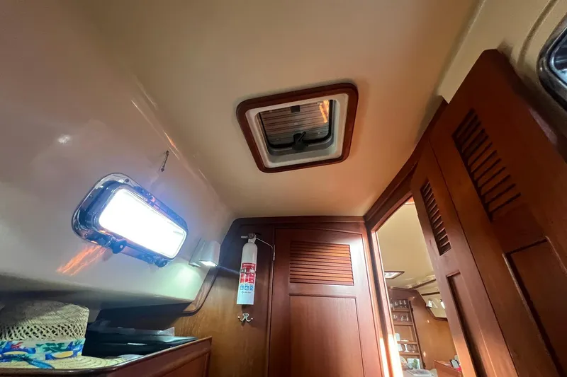 Slide: The Image of Interior of 1994 Island Packet 44 cutter sailboat with wooden cabinetry and ceiling hatch. - 105