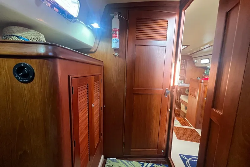 Slide: The Image of Interior of 1994 Island Packet 44 cutter, featuring wooden cabinetry and nautical decor. - 106