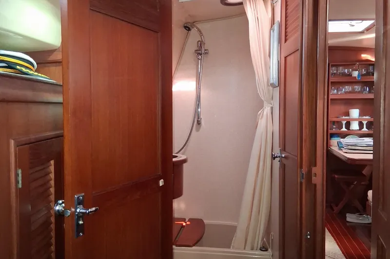 Slide: The Image of Interior of 1994 Island Packet 44 cutter, featuring shower and wooden cabinetry. - 107