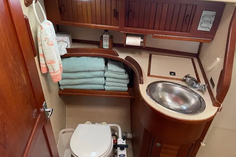 Slide: The Image of 1994 Island Packet 44 cutter bathroom with sink, towels, and wooden cabinetry. - 108
