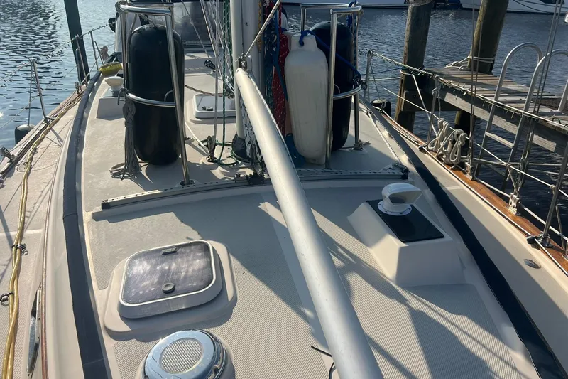 Slide: The Image of 1994 Island Packet 44 cutter sailboat deck with rigging and dock view. - 11