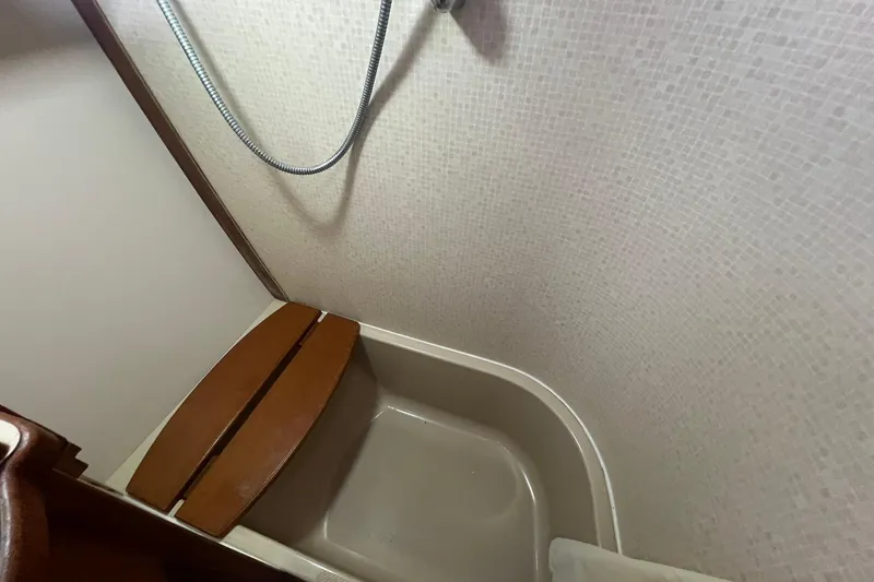 Slide: The Image of Shower area in 1994 Island Packet 44 cutter sailboat with wooden seat and hose. - 111