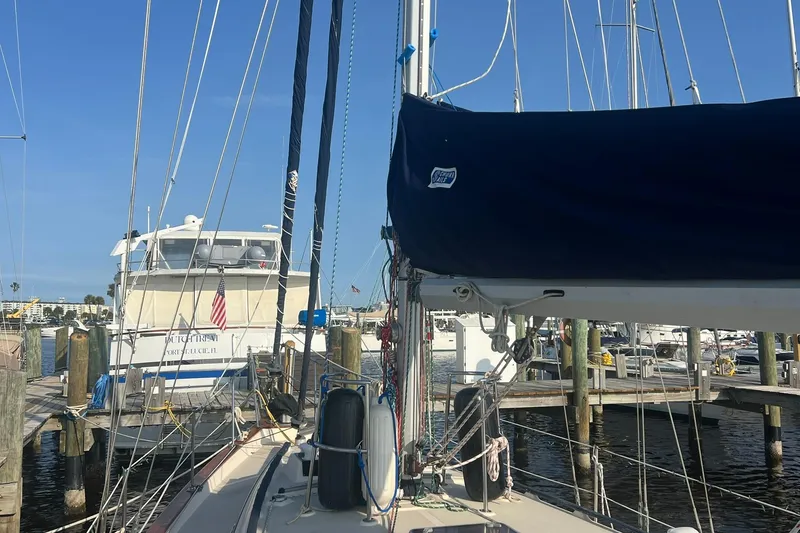 Slide: The Image of 1994 Island Packet 44 cutter sailboat docked at marina with clear blue sky. - 17