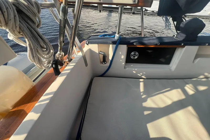 Slide: The Image of 1994 Island Packet 44 cutter sailboat cockpit with ropes and seating in sunlight. - 24