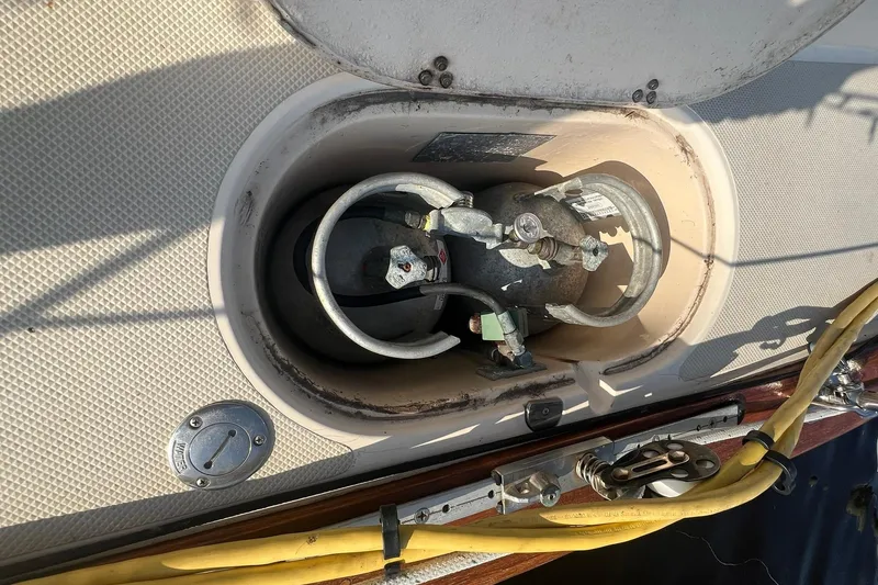 Slide: The Image of Open compartment on 1994 Island Packet 44 cutter sailboat showing propane tank and hoses. - 30