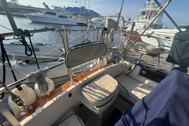 Slide: The Image of 1994 Island Packet 44 cutter sailboat cockpit with marina view and nautical equipment. - 38