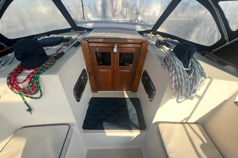 Slide: The Image of 1994 Island Packet 44 cutter cockpit with ropes, wooden hatch, and seating area. - 41