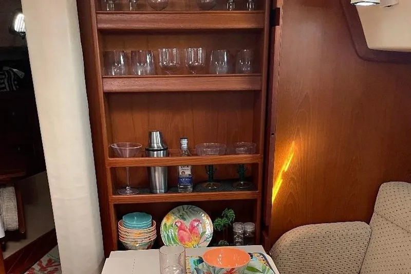 Slide: The Image of Interior of 1994 Island Packet 44 cutter with wooden shelves and colorful dishware. - 69