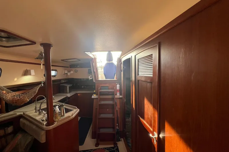 Slide: The Image of Interior of 1994 Island Packet 44 cutter sailboat with wooden cabinetry and kitchen area. - 76