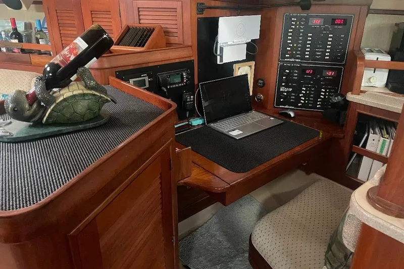 Slide: The Image of Interior of a 1994 Island Packet 44 cutter with navigation station and turtle wine holder. - 83