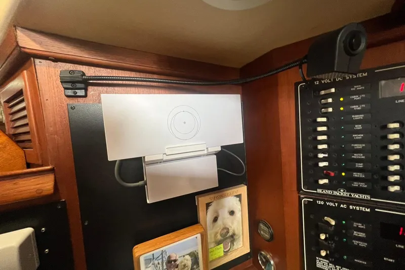 Slide: The Image of Electrical panel on 1994 Island Packet 44 cutter yacht with control switches and personal photos. - 86