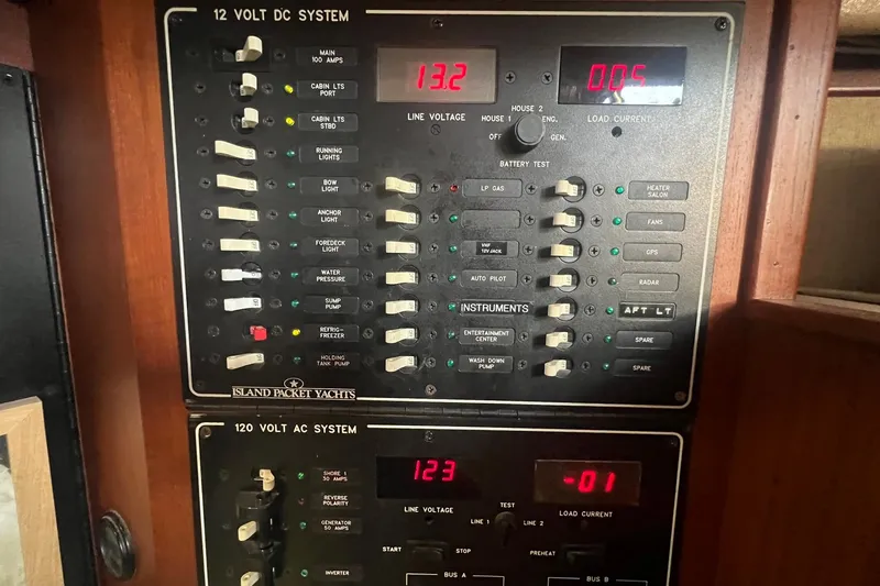 Slide: The Image of Electrical control panel on a 1994 Island Packet 44 cutter yacht, showing voltage and switches. - 88