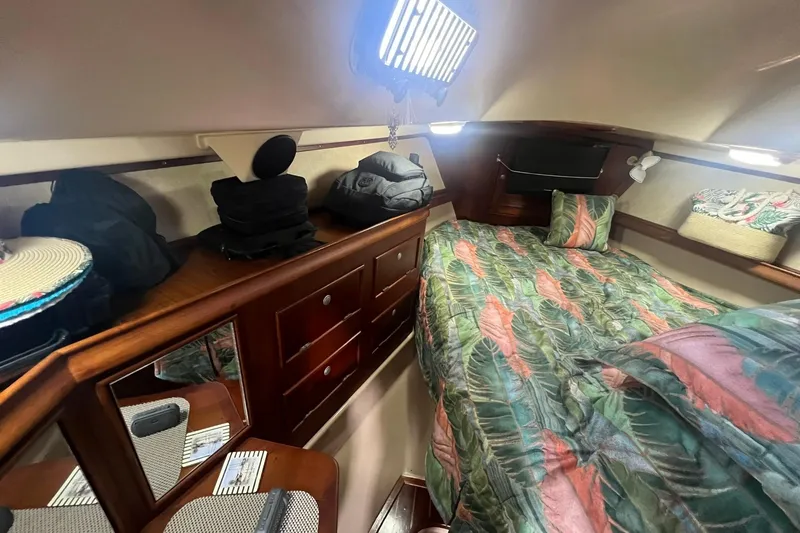 Slide: The Image of Cozy cabin interior of 1994 Island Packet 44 cutter with tropical bedding and wooden storage. - 89