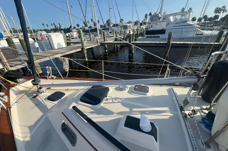 Slide: The Image of 1994 Island Packet 44 cutter sailboat docked at marina with clear sky. - 9
