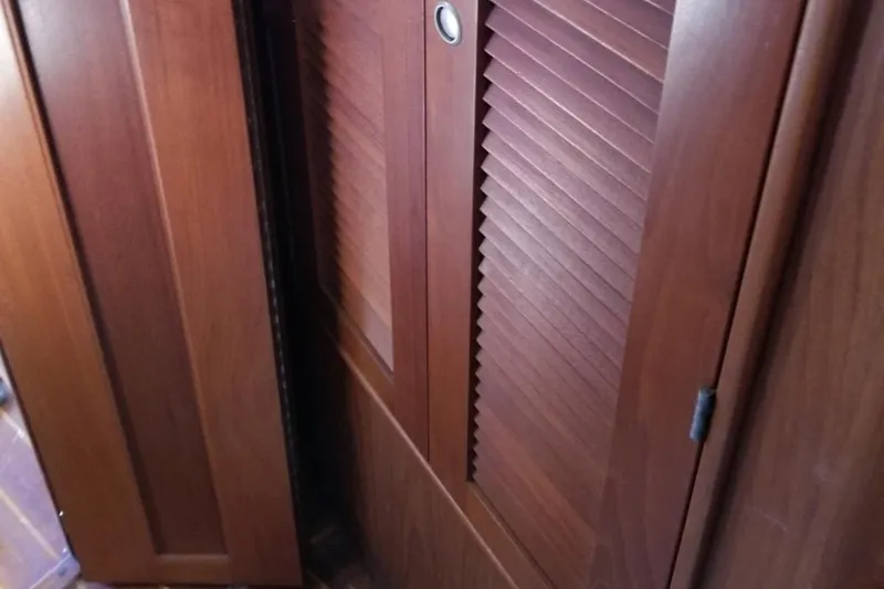 Slide: The Image of Wooden interior of 1994 Island Packet 44 cutter sailboat, featuring louvered cabinet doors. - 94