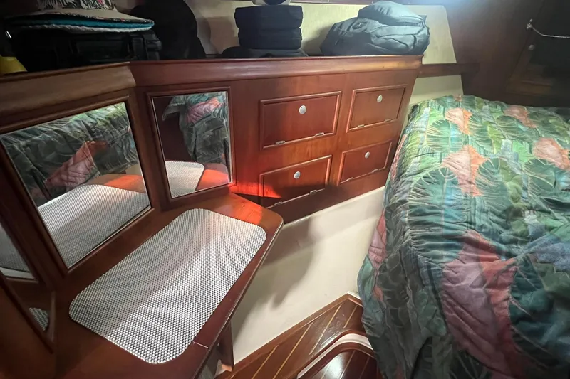Slide: The Image of Cozy cabin interior of 1994 Island Packet 44 cutter with wooden cabinetry and colorful bedding. - 95