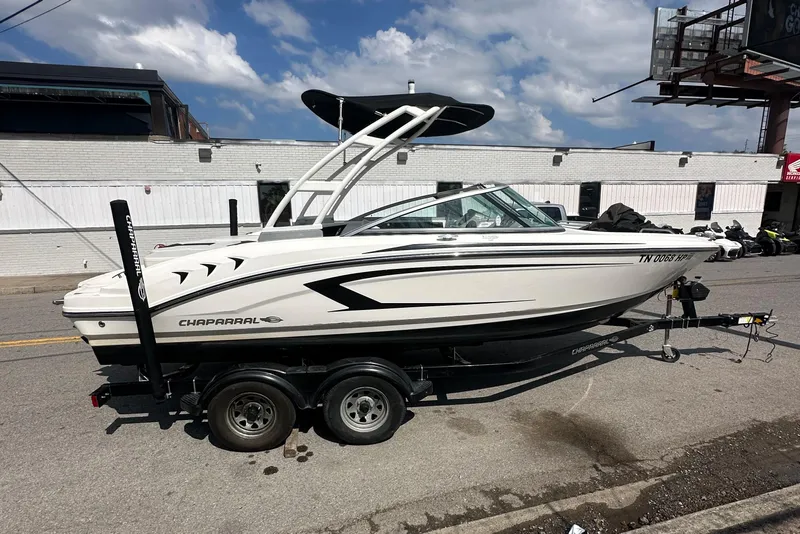 The Image of 2018 Chaparral 21 H2O Sport boat on trailer, parked outdoors near a building. - 0