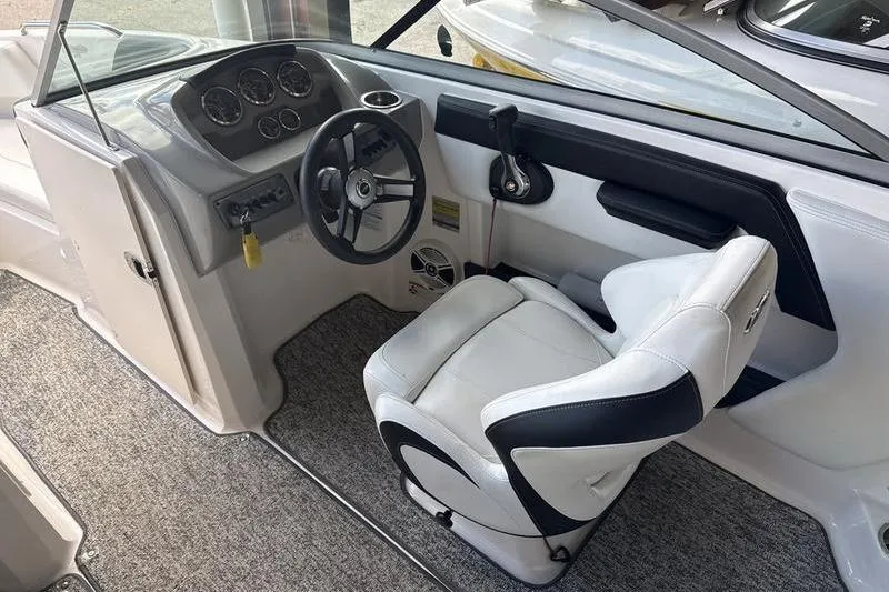 Slide: The Image of 2018 Chaparral 21 H2O Sport boat interior with white captain's seat and gray carpet. - 10
