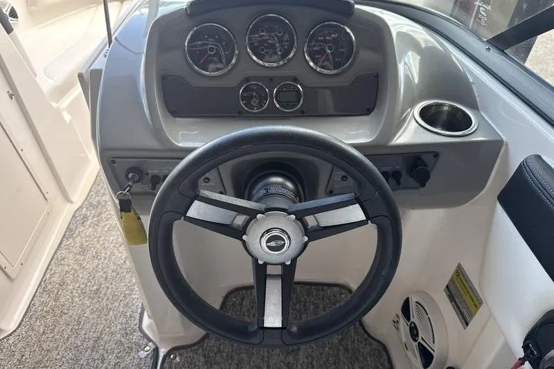 Slide: The Image of 2018 Chaparral 21 H2O Sport boat interior with white captain's seat and gray carpet. - 11