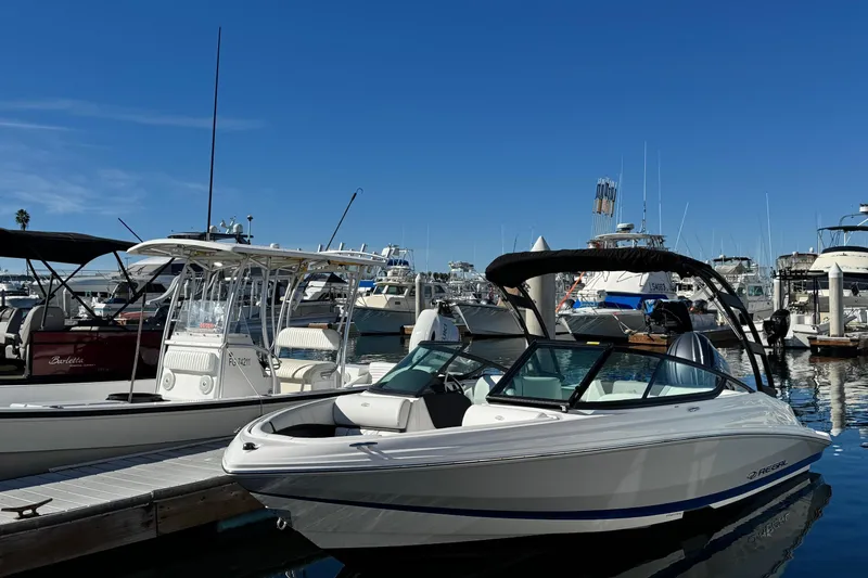 Slide: The Image of 2026 Regal 21 OBX boat docked at a marina under clear blue skies. - 1