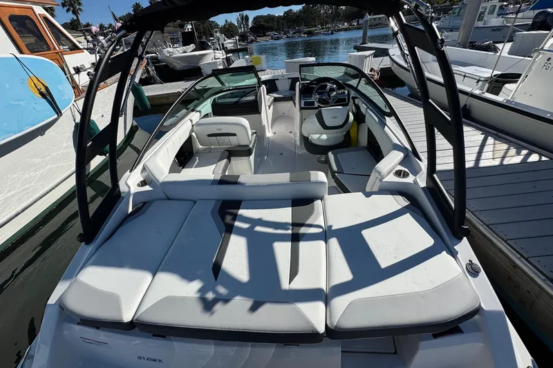 Slide: The Image of 2026 Regal 21 OBX boat docked, featuring sleek white seating and modern design. - 12