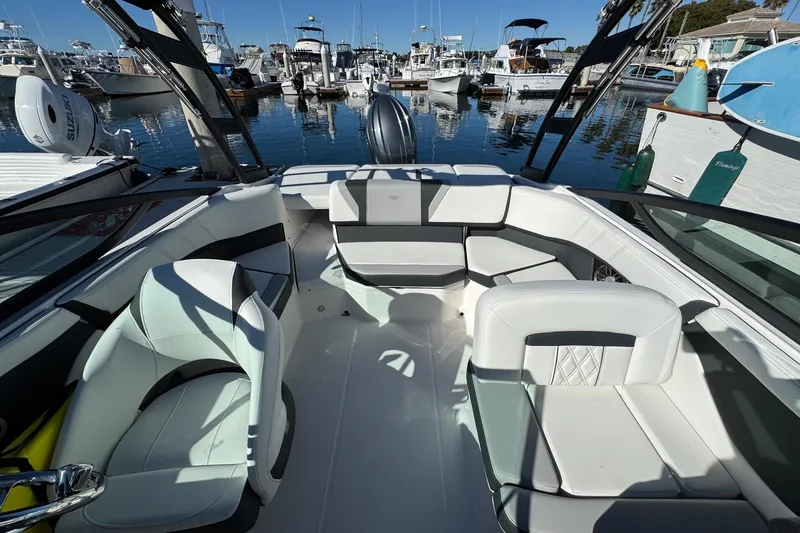 Slide: The Image of 2026 Regal 21 OBX boat interior with white seating, docked at a marina. - 14