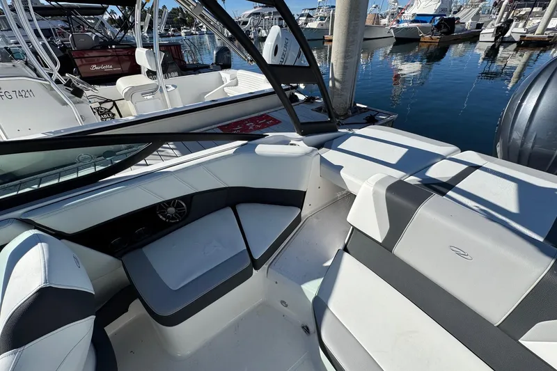 Slide: The Image of 2026 Regal 21 OBX boat interior with sleek seating, docked at a marina. - 16
