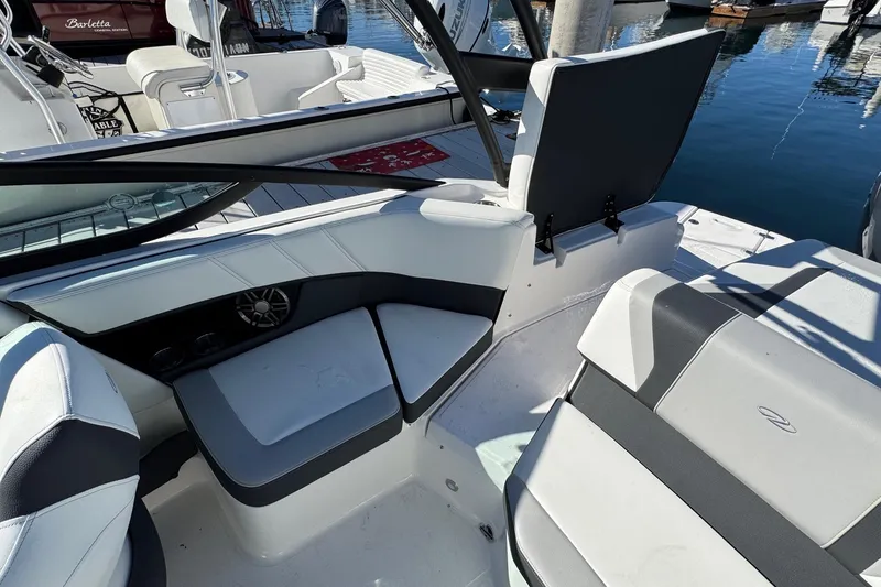 Slide: The Image of 2026 Regal 21 OBX boat interior with white and gray seating at a marina. - 17