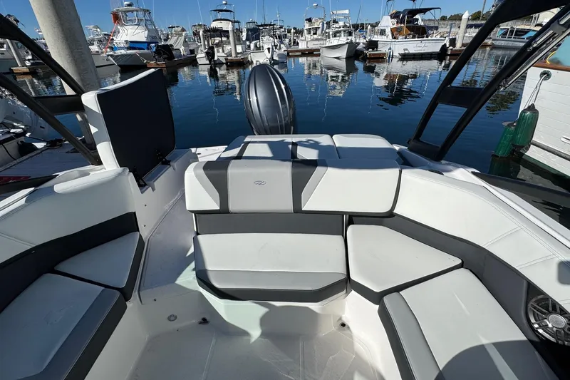 Slide: The Image of 2026 Regal 21 OBX boat interior with sleek seating at a marina. - 18