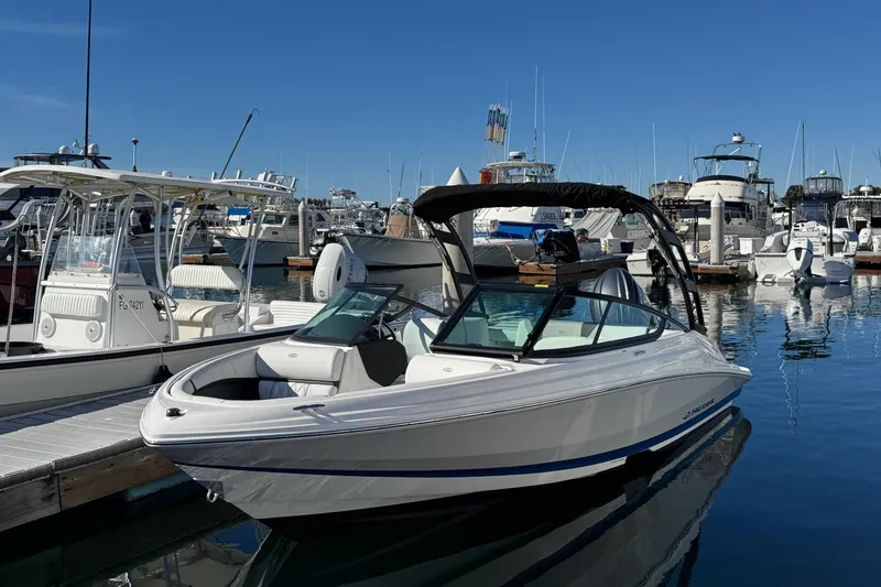 Slide: The Image of 2026 Regal 21 OBX boat docked at a marina under clear blue skies. - 2