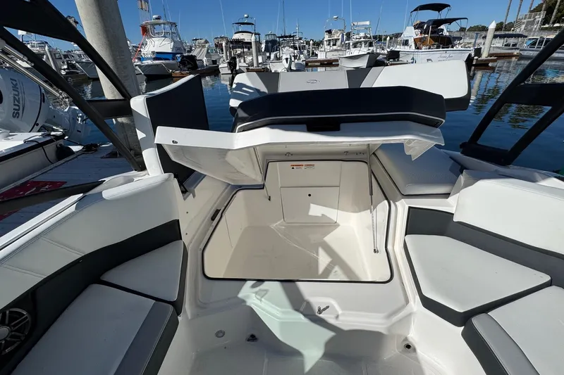 Slide: The Image of 2026 Regal 21 OBX boat interior with seating and storage, docked at a marina. - 20
