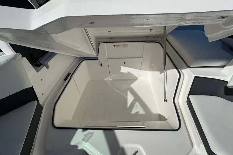 Slide: The Image of 2026 Regal 21 OBX boat storage compartment with open hatch, showcasing spacious interior design. - 21