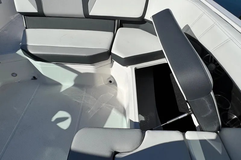 Slide: The Image of 2026 Regal 21 OBX boat interior with open storage compartment and cushioned seating. - 25