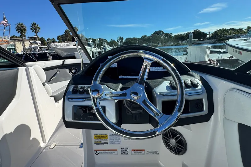 Slide: The Image of 2026 Regal 21 OBX boat dashboard with steering wheel, docked in sunny marina. - 35