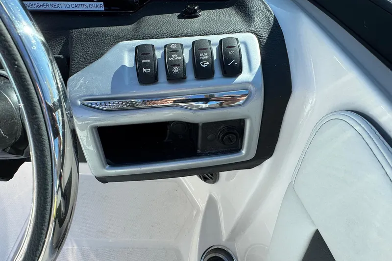 Slide: The Image of Control panel of 2026 Regal 21 OBX boat with various switches and steering wheel. - 38