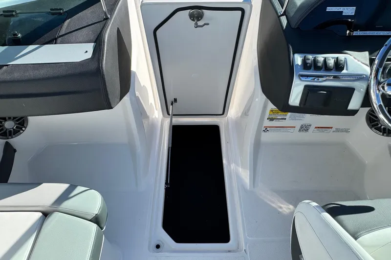 Slide: The Image of 2026 Regal 21 OBX boat interior with open storage compartment and control panel. - 41