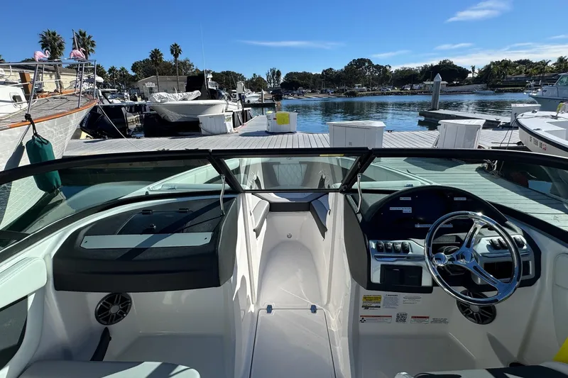 Slide: The Image of 2026 Regal 21 OBX boat interior at marina, featuring steering wheel and dashboard. - 42