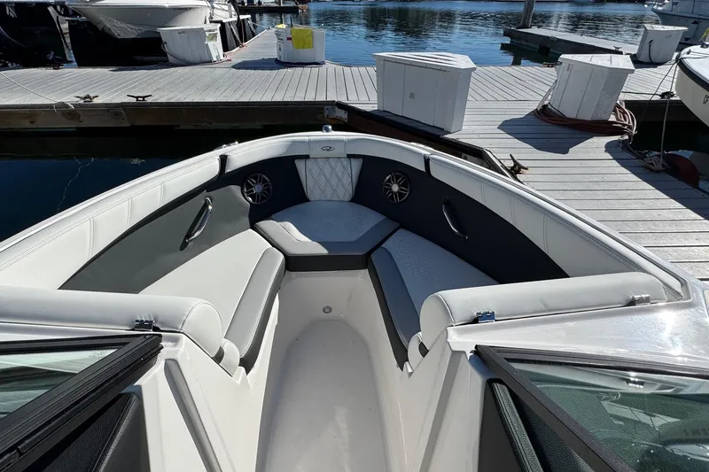 Slide: The Image of 2026 Regal 21 OBX boat interior with cushioned seating, docked at marina. - 43