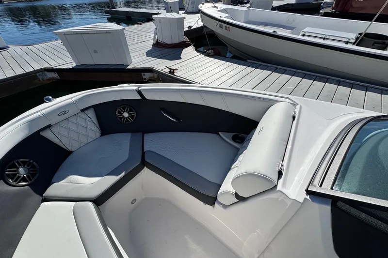 Slide: The Image of 2026 Regal 21 OBX boat interior with cushioned seating at a dock. - 44