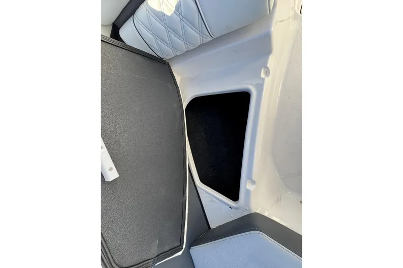 Slide: The Image of 2026 Regal 21 OBX boat interior storage compartment with cushioned seating. - 50