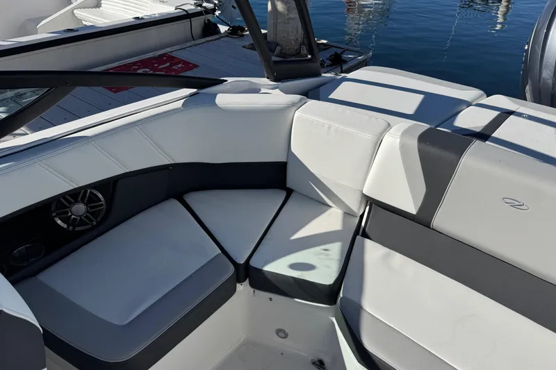 Slide: The Image of 2026 Regal 21 OBX boat interior with cushioned seating and speaker, docked by water. - 53