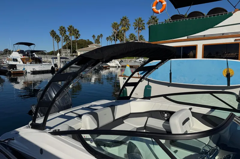 Slide: The Image of 2026 Regal 21 OBX boat docked in a sunny marina with palm trees. - 56