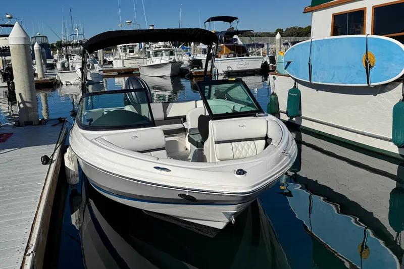 Slide: The Image of 2026 Regal 21 OBX boat docked at marina with paddleboard nearby. - 6