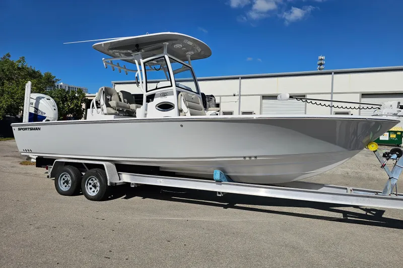 The Image of 2021 Sportsman Masters 267OE Bay Boat on trailer, parked outdoors under clear blue sky. - 0